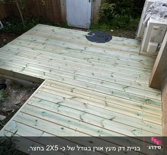 דק עץ חדש בגינה עם צמחייה מסביב